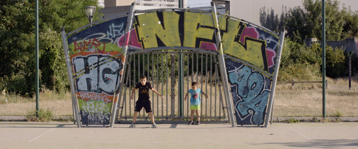 Photogramme du film La Dalle de l’A3, deux enfants sur un terrain de foot en béton